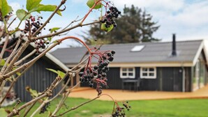 A rustic building with a sloped roof and a small porch. - 4 Star Holiday Home in Lokken (Lokken)