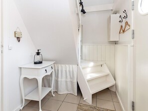 Un baño blanco con tocador, inodoro y zona de ducha.