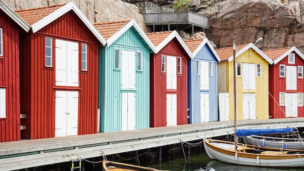 A row of colorful wooden buildings with a dock and boats. - 4 Person Holiday Home in Smogen (Smogen)