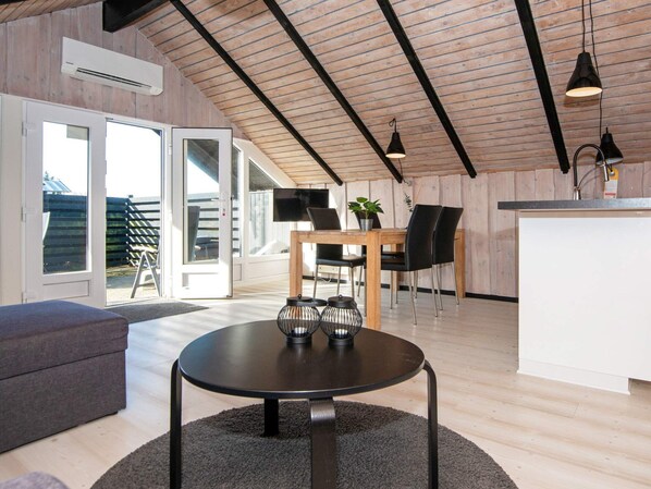 A modern interior with a dining area, a kitchen, and a seating space. - 4 Person Holiday Home in Hvide Sande (Hvide Sande)
