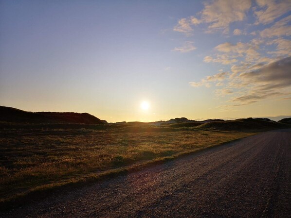 A rural road with a clear sky and the sun setting or rising. - 4 Person Holiday Home in Hvide Sande (Hvide Sande)