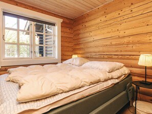 A wooden-paneled room with a bed, a window, and a lamp. - Holiday Home in VÃ¦ggerlÃ¸se (Vaeggerlose)