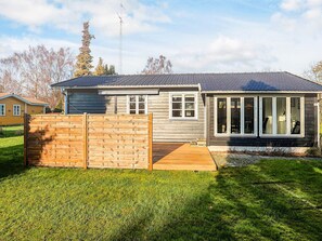 A two-story house with a fenced backyard, a covered patio, and a satellite dish.