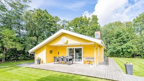 Un bâtiment jaune doté d’une terrasse, de sièges en plein air et d’une enseigne indiquant « Kuglerpark ».