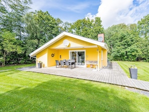A yellow building with a deck, outdoor seating, and a sign that reads "Kuglerpark".