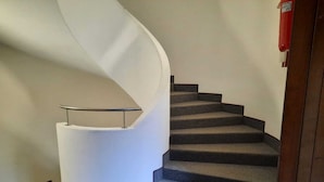 A spiral staircase with a handrail and carpeted steps. - Apartment in Cervinia With Ski Access (Valtournenche)