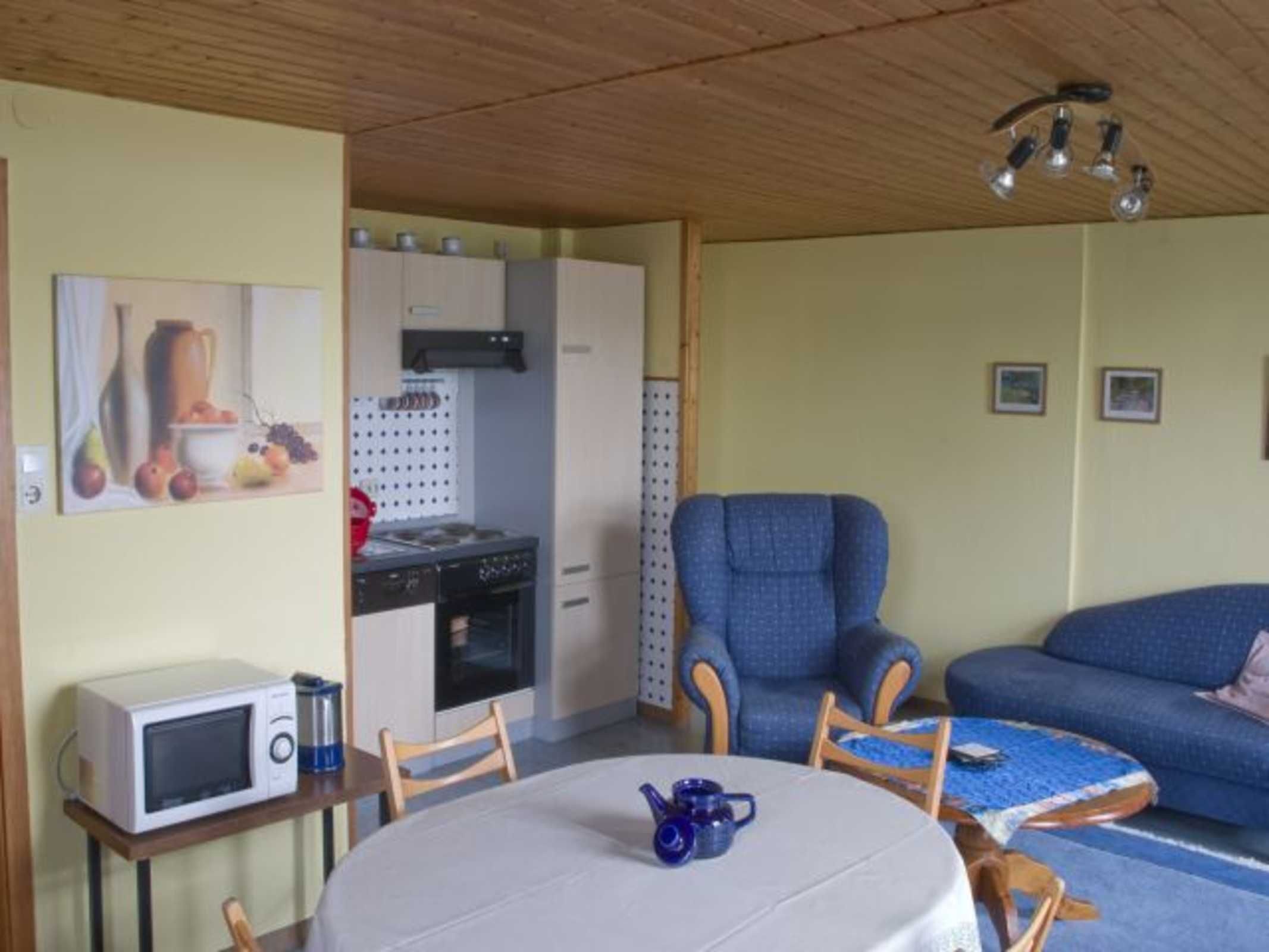 A compact living space with a kitchenette, a dining area, and a seating area.