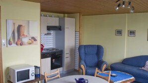 A compact living space with a kitchenette, a dining area, and a seating area.