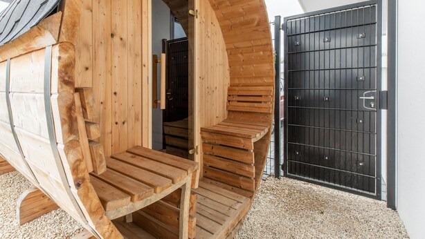 A wooden sauna structure with a door and steps leading inside. - Brand new Luxury Villa on a Small-scale Park (Zeewolde)