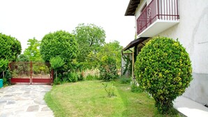 A stone pathway leading to a white building with a red balcony. - Rustic Moncucco Village Retreat (Moncucco Torinese)