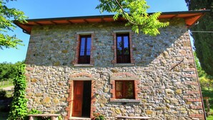 Un bâtiment en pierre avec une porte en bois et deux fenêtres.
