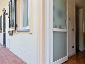 Ein Zimmer mit einer Schiebeglastür, einem Fenster mit Rollläden und einer Tür mit Milchglasfenster.
