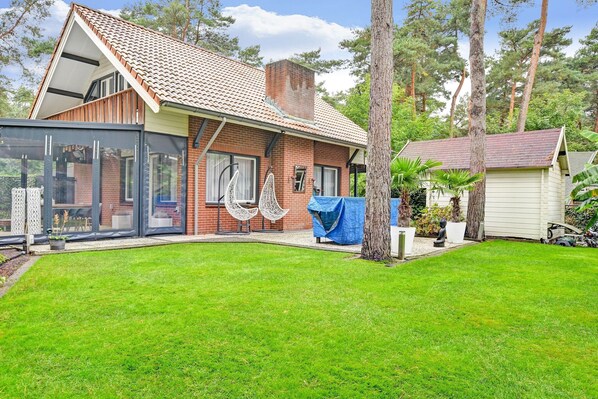 A house with a sloped roof, a brick exterior, and a glass enclosure.
