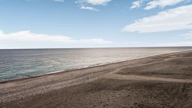 A beach with a clear sky and calm sea.