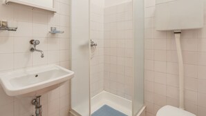 A bathroom with a sink, mirror, shower, and toilet. - Alluring Apartment in Medulin near Beach (Medulin)