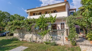 A two-story building with a balcony, surrounded by greenery and a stone pathway. - Alluring Apartment in Medulin near Beach (Medulin)
