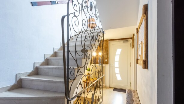 A staircase with a wrought iron railing leading to a door. - Fabulous Apartment in Bichlbach (Bichlbach)