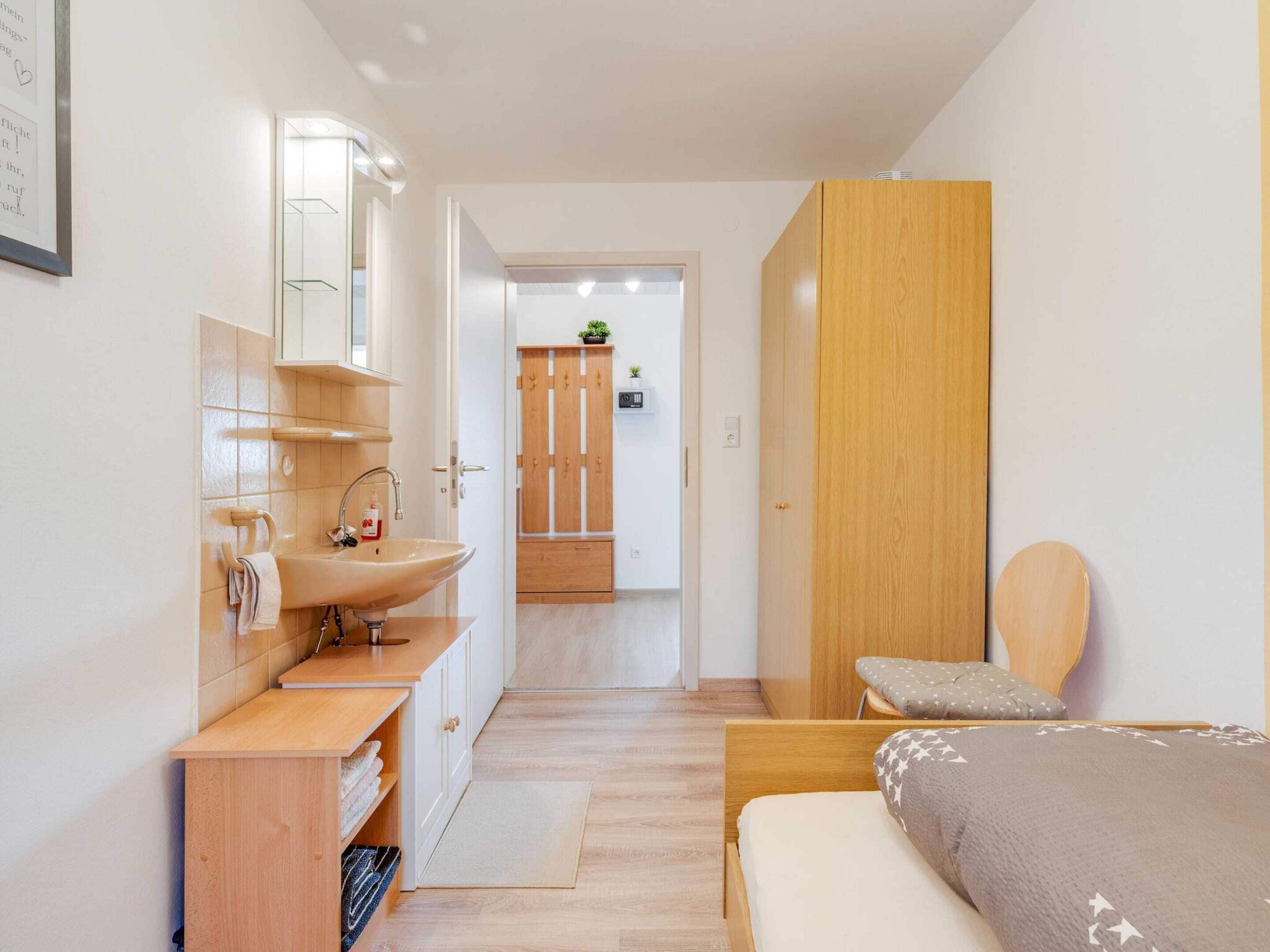 Et moderne soveværelse med en træseng, et natbord og en indbygget garderobe.