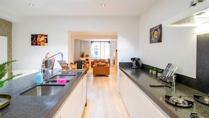 A modern kitchen with a central island, a dining area, and a living room. - Elegant Holiday Home in Nieuwpoort near Beach (Nieuwpoort)