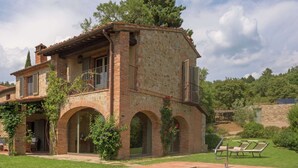 A stone villa with a swimming pool, featuring arched windows and a balcony with outdoor furniture. - Villa in Arezzo With Pool and Vineyards (Arezzo)