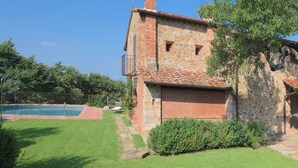 A stone building with a swimming pool, surrounded by a well-maintained lawn and trees. - Villa in Arezzo With Pool and Vineyards (Arezzo)