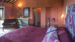 A bedroom with a large bed, a chair, a dresser, and a mirror. - Villa in Arezzo With Pool and Vineyards (Arezzo)