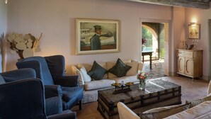 A living room with a sofa, armchairs, a coffee table, and a painting on the wall. - Villa in Arezzo With Pool and Vineyards (Arezzo)