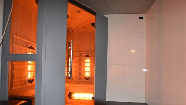 A sauna room with a wooden bench, a bench with a backrest, and a bench with a backrest. - House in Reutum With Jacuzzi & Forest View (Reutum)