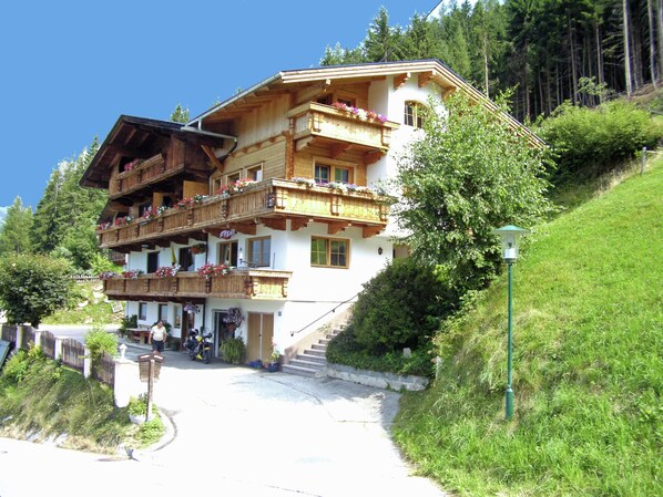 A multi-story chalet with wooden balconies, a ski lift, and a mountain backdrop. - Apartment in Gerlosberg Near Ski Lift (Gerlosberg)