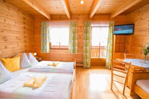 A cabin with two beds, a TV, and a dining area. - Cozy Holiday Apartment Close to the Slopes (Kleinarl)