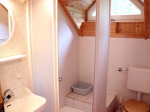 A bathroom with a shower, toilet, and sink.