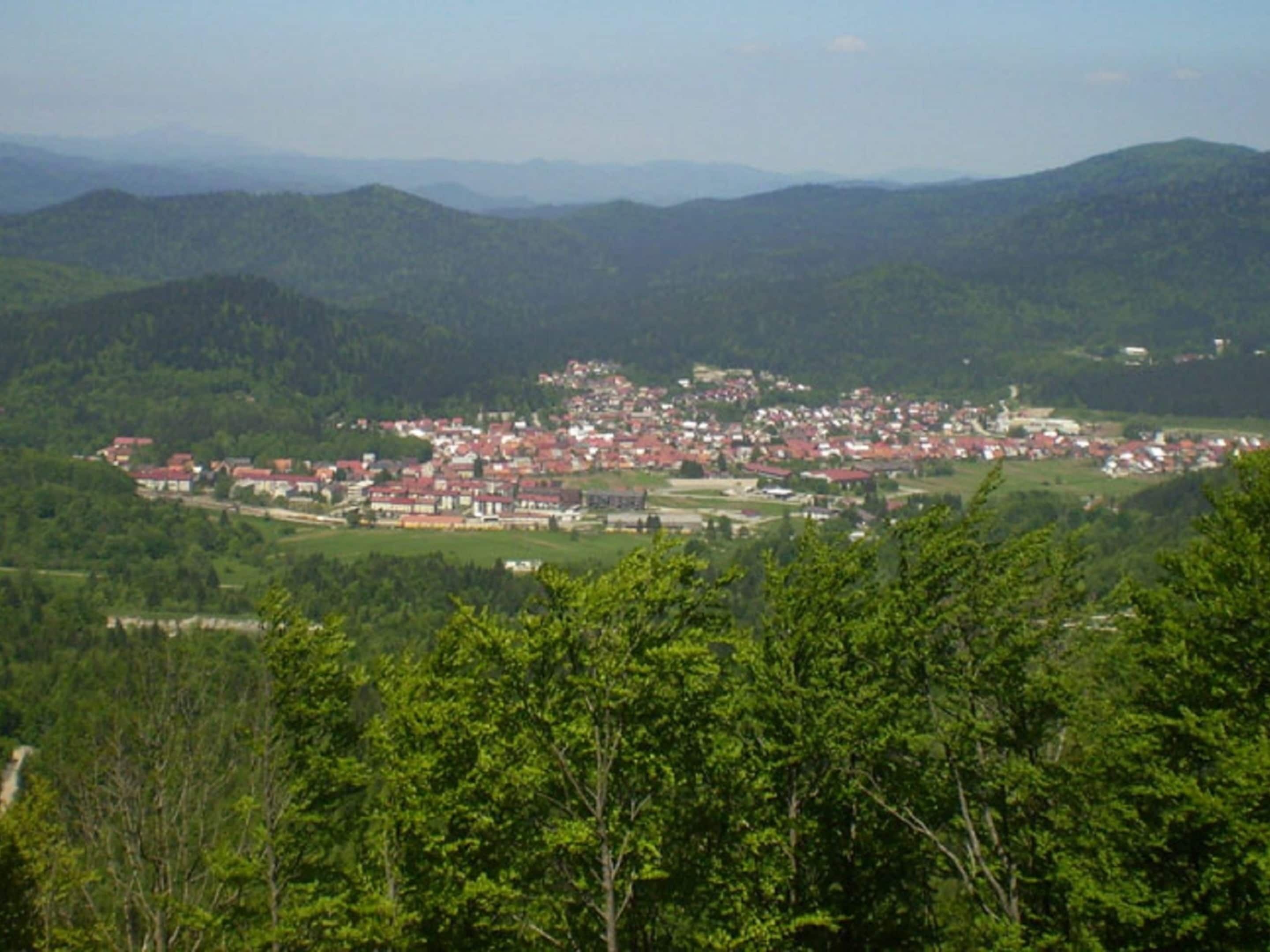 A town nestled in a valley surrounded by forested hills.