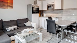 A modern apartment with a living room, dining area, and kitchen. - Snug Apartment in Kalkhorst with Terrace near City Center (Kalkhorst)