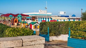 A seaside resort with a bar, restaurant, and children's play area.