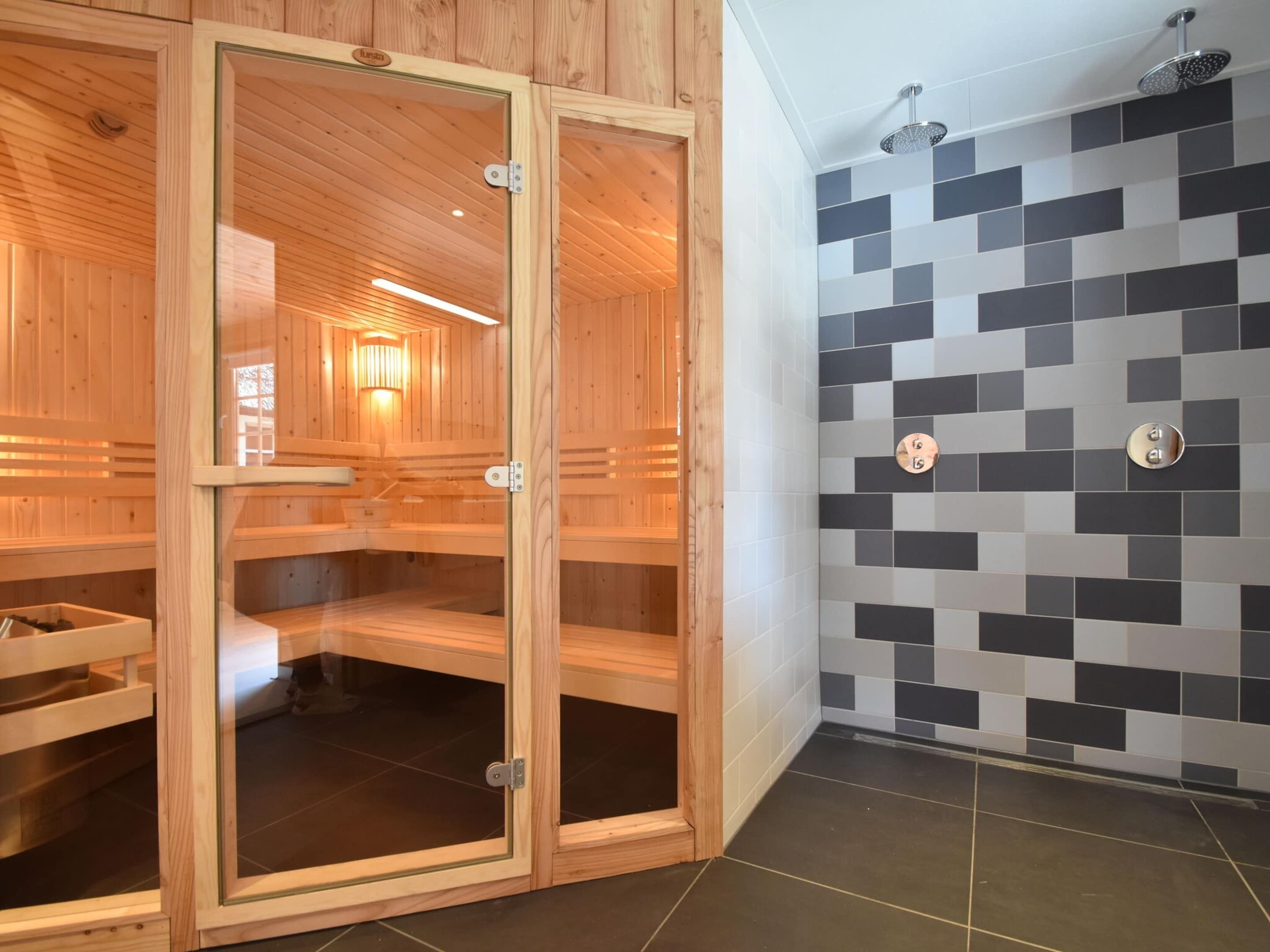 Sauna, jossa on puuseinät ja laatoitettu suihkutila.