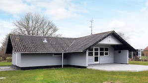 A single-story building with a sloped roof, a small porch, and a window. - 6 Person Holiday Home in Humble (Sydlangeland)
