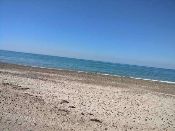 A beach with a clear sky and calm sea.