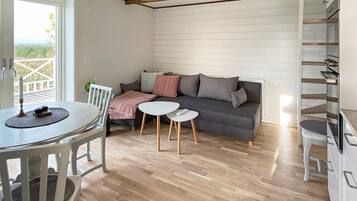 Una sala acogedora con un sofá, una mesa de comedor y una pequeña mesa de centro.