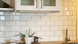 A kitchen with white cabinets, a stainless steel sink, and a potted plant on the counter. - 4 Person Holiday Home in Farjestaden (Farjestaden)