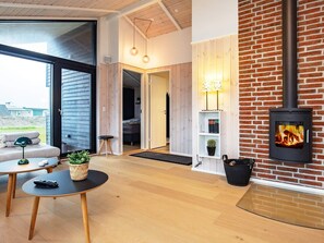 A modern living space with a fireplace, wooden flooring, and a cozy seating area.