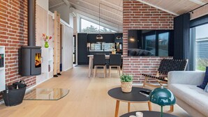 A modern living space with a fireplace, a dining area, and a kitchen.