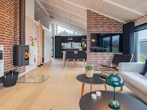 A modern living space with a fireplace, a dining area, and a kitchen.