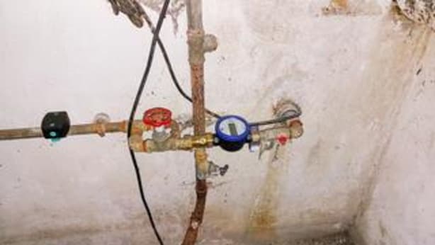 A water pipe with a pressure gauge and a valve.