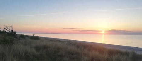 A beach with a sunset over the water.