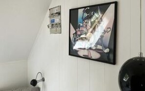 A room with a framed artwork on the wall, a black spherical object, and a white wall. - Holiday Home in NykÃ¸bing Sj (Nykobing Sjaelland)