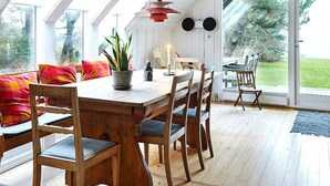 Un coin repas avec une table en bois, des chaises et une plante en pot.