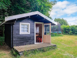 A small cabin with a wooden exterior, a single window, and a door. - 6 Person Holiday Home in Jaegerspris (Jægerspris)