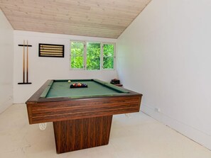 Enjoy a game of pool in this cozy room with a pool table and natural views.