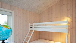 A bunk bed with a ladder, a globe on a desk, and wooden panel walls. - Holiday Home in Sæby (Sæby)