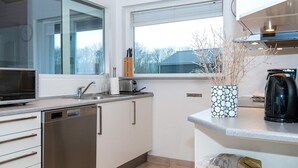 Eine moderne Küche mit einer Spülmaschine, einem Toaster und einer Kaffeemaschine auf der Arbeitsfläche.